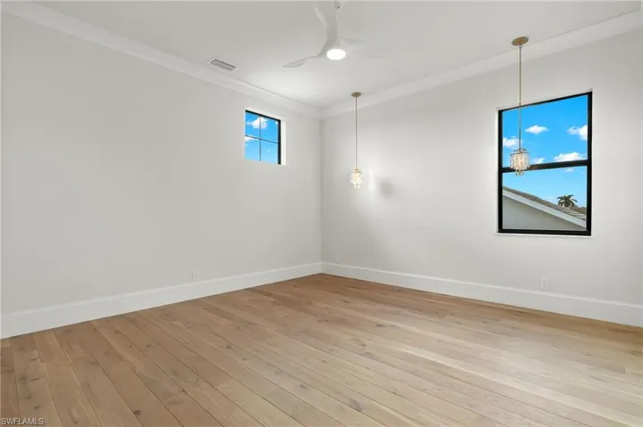 Spare room with ornamental molding, light hardwood / wood-style flooring, and ceiling fan