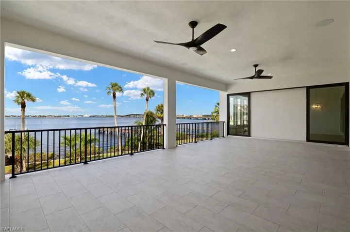 View of patio featuring a balcony, a water view, and ceiling fan