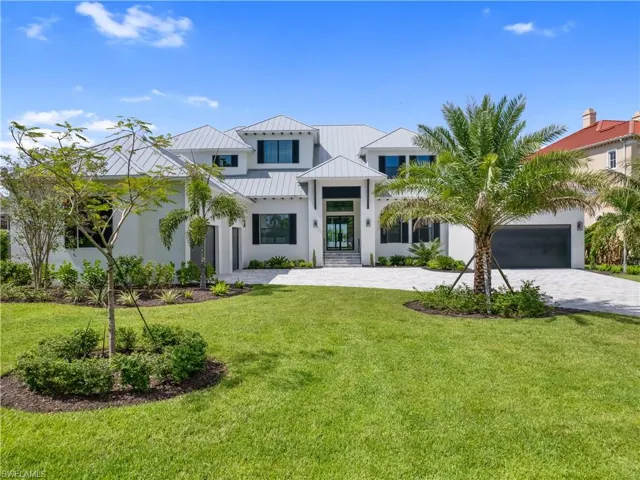 View of front of home with a front yard and a garage