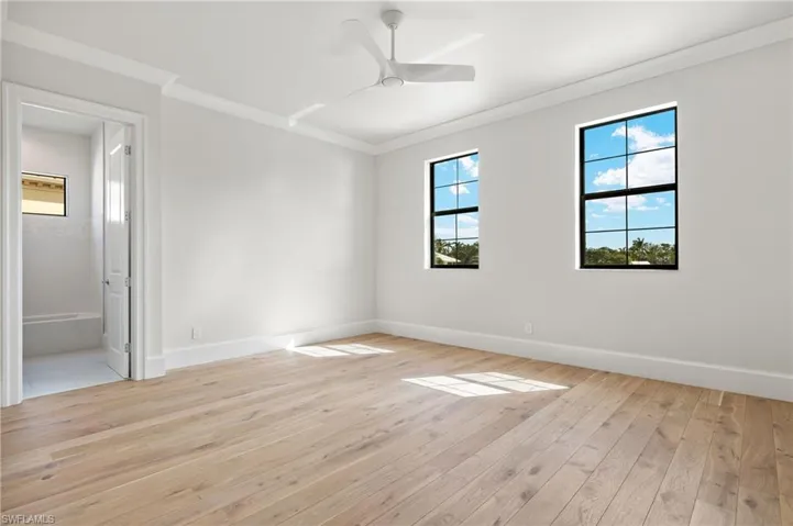 Unfurnished room featuring crown molding, light wood-type flooring, and ceiling fan