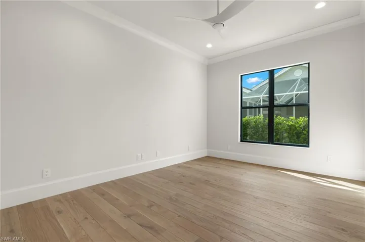 Spare room featuring ceiling fan, ornamental molding, and light wood-type flooring