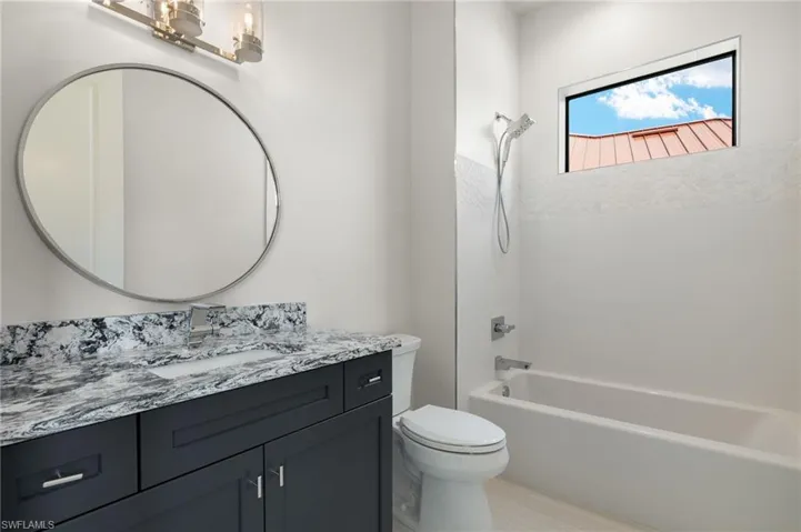 Full bathroom featuring vanity, toilet, and washtub / shower combination