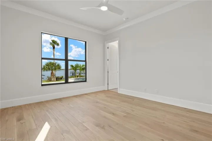 Unfurnished room featuring light hardwood / wood-style floors, ornamental molding, and ceiling fan