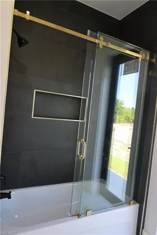 Full bathroom featuring a shower with door and a tub to relax in