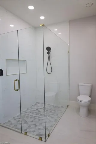 Full bathroom with baseboards, a marble finish shower, recessed lighting, toilet, and marble finish floor