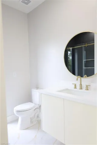 Bathroom with visible vents, toilet, and vanity