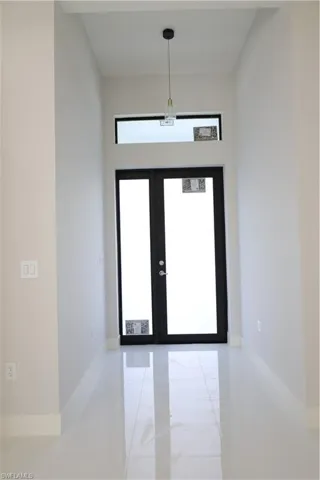 Entryway featuring french doors, baseboards, and marble finish floor