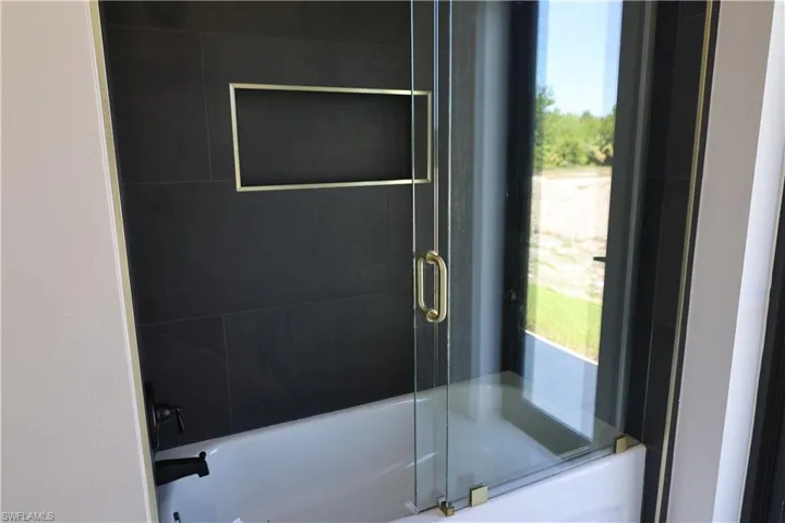 Full bathroom with bath / shower combo with glass door