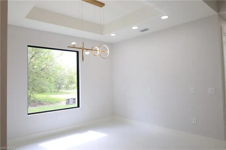 Spare room with visible vents, recessed lighting, and a tray ceiling