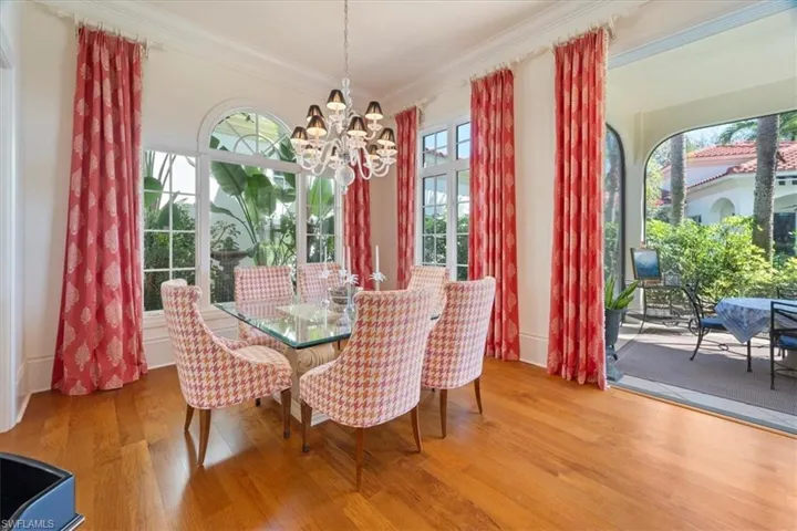 Dining area featuring crown molding, a chandelier, and wood finished floors
