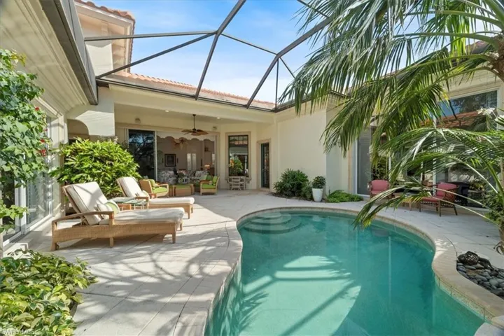Pool featuring ceiling fan, a patio, and glass enclosure