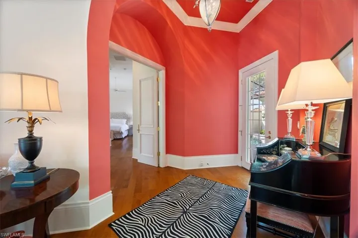 Foyer entrance with arched walkways, ornamental molding, wood finished floors, and baseboards