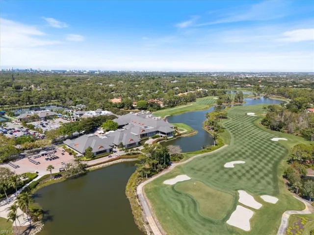 Birds eye view of property with golf course view and a water view