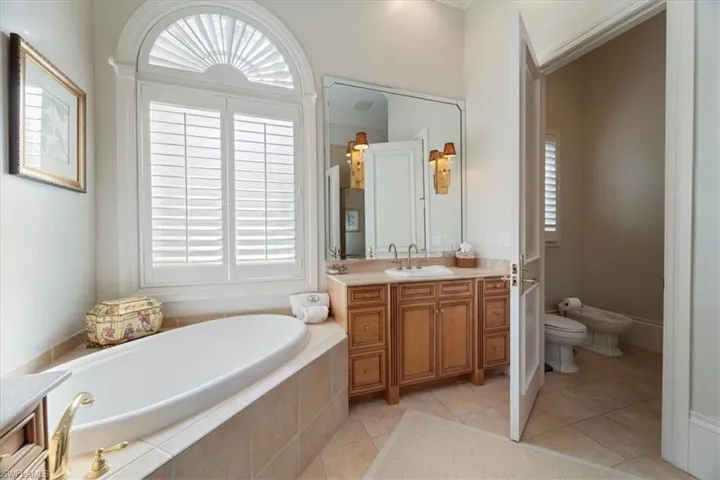 Full bathroom featuring tile patterned flooring, a bidet, a bath, and vanity