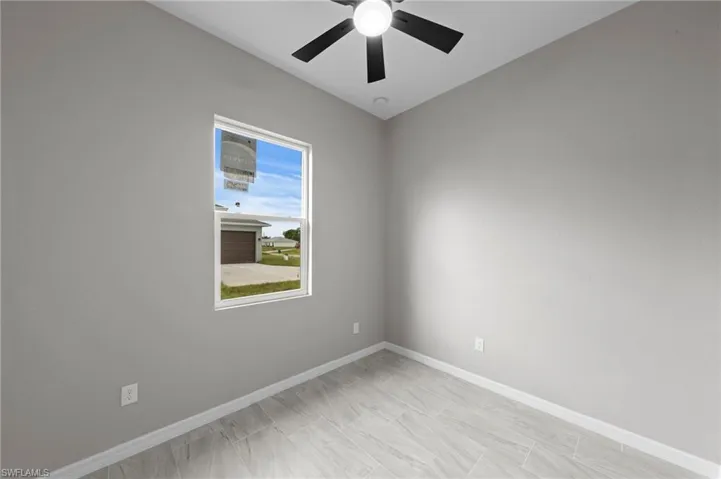 Empty room featuring baseboards and ceiling fan
