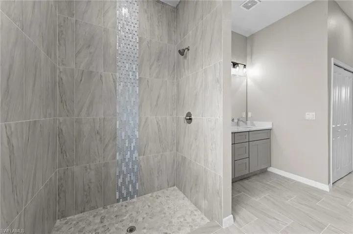 Full bath with a tile shower and vanity
