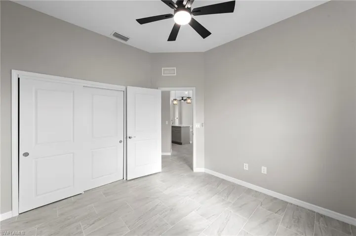 Unfurnished bedroom with ceiling fan, a chandelier, and a closet