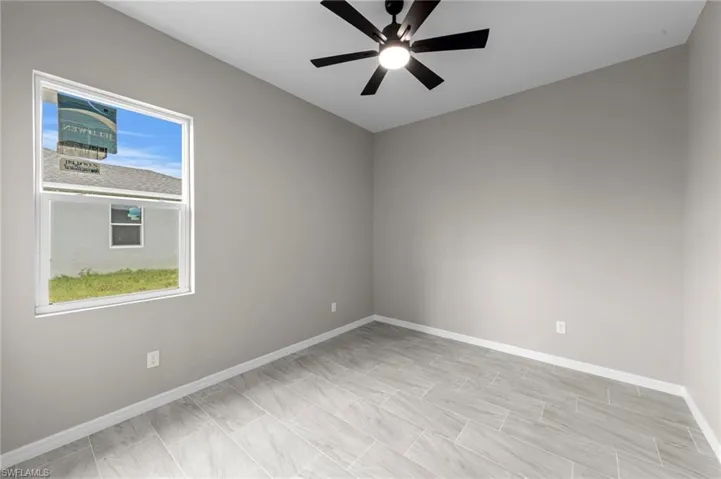 Empty room featuring baseboards and a ceiling fan