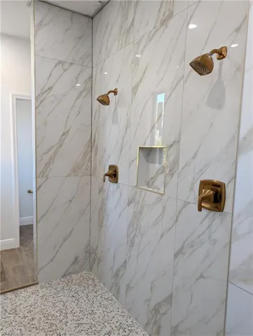 Full bath with a marble finish shower