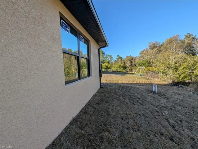 View of side of property with a playground and stucco siding