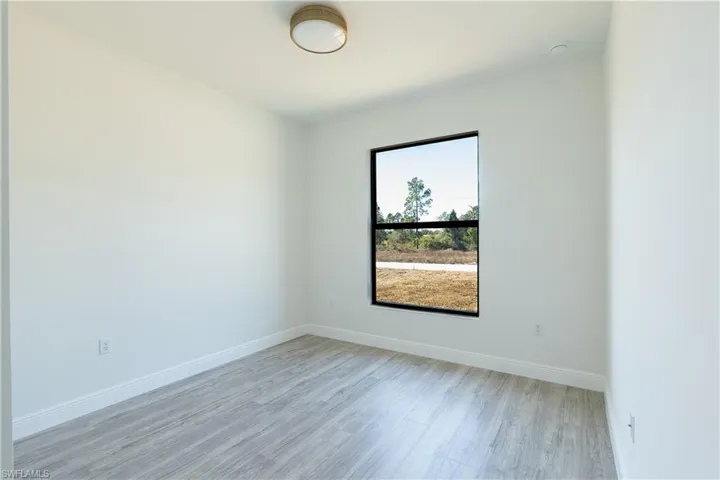 Spare room with baseboards and light wood-type flooring