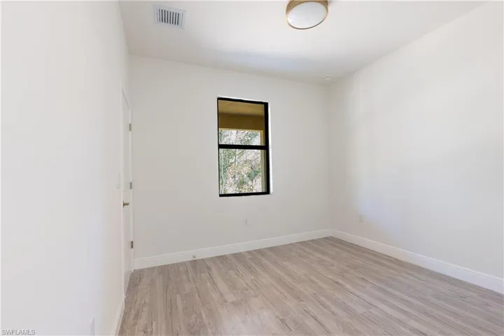 Empty room with light wood finished floors and baseboards