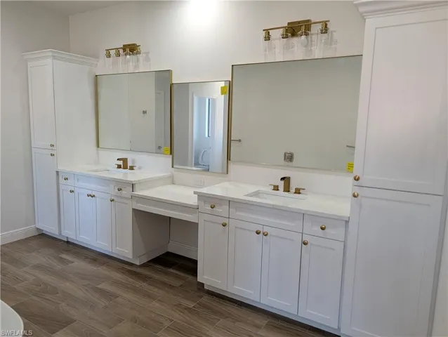 Full bath with two vanities and wood finish floors