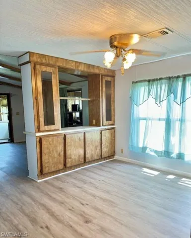 Kitchen featuring beam ceiling, hardwood / wood-style flooring, and ceiling fan