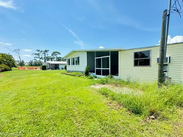 Rear view of house featuring a large yard with lots of potential