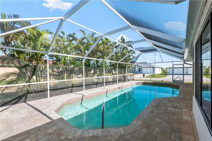 View of swimming pool with a patio and glass enclosure