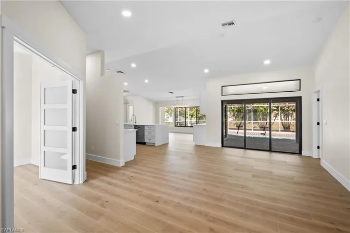 Unfurnished living room with sink and light wood-type flooring