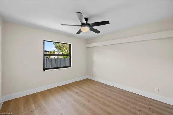 Unfurnished room with ceiling fan and light wood-type flooring