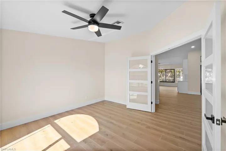 Empty room with ceiling fan and wood-type flooring