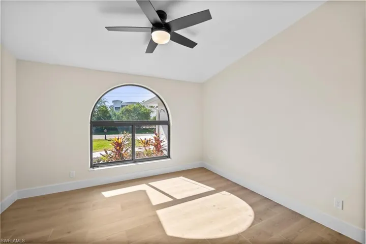 Unfurnished room featuring ceiling fan, light hardwood / wood-style flooring, and vaulted ceiling