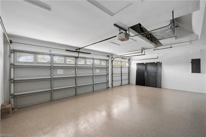 Garage with electric panel and a garage door opener