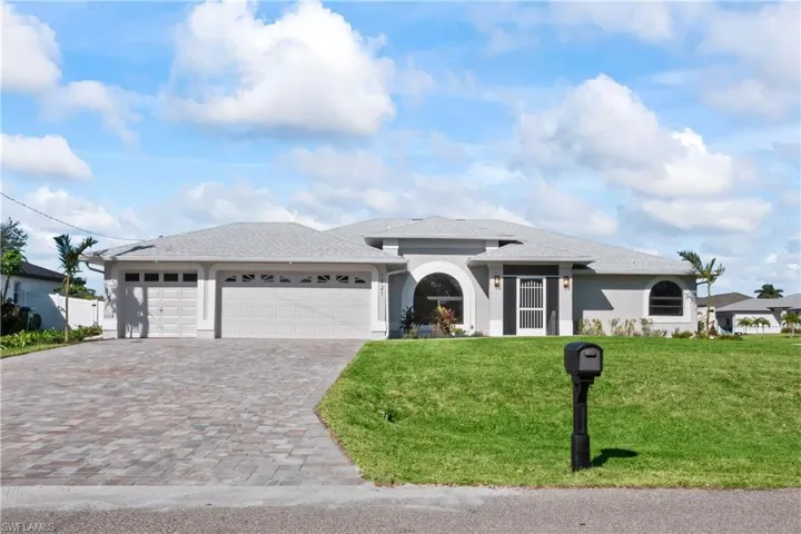 View of front of home with a front yard and a garage