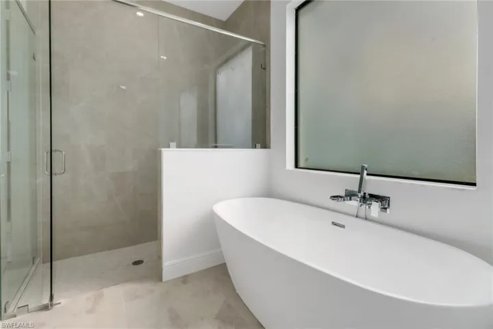 Bathroom featuring shower with separate bathtub.