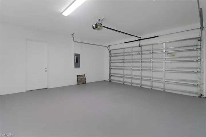 Garage featuring a garage door opener and electric panel