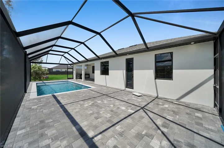Outdoor pool featuring a patio and glass enclosure