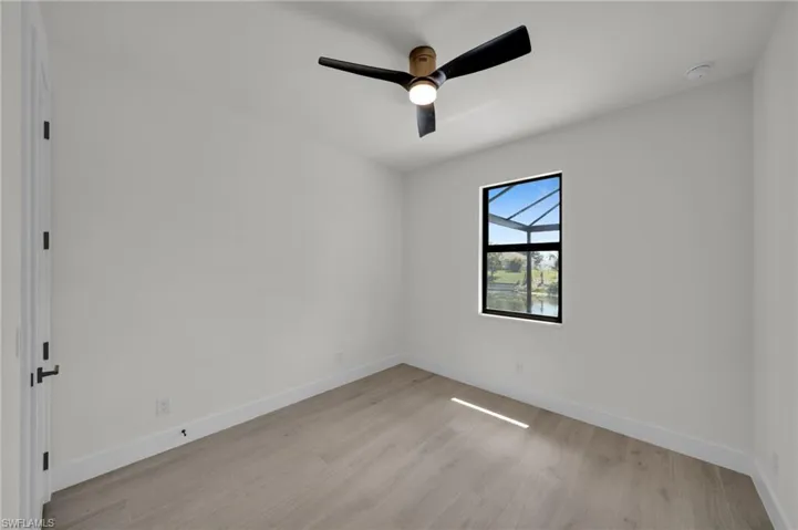 Empty room with light wood-style floors, baseboards, a ceiling fan, and a smoke detector
