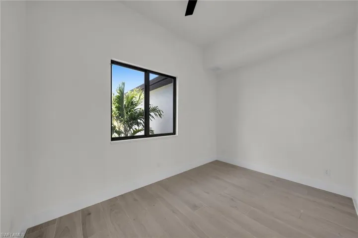 Empty room with light wood-style floors, ceiling fan, and baseboards