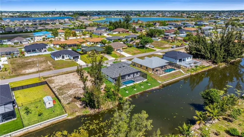 Aerial perspective of suburban area featuring a nearby body of water