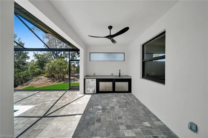 Unfurnished sunroom with a sink and beverage cooler
