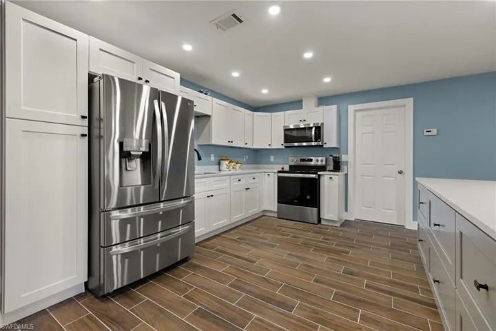 Kitchen featuring white cabinets, sink, and appliances with stainless steel finishes