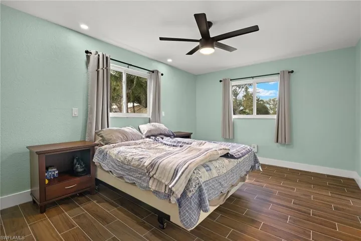 Bedroom featuring ceiling fan and multiple windows