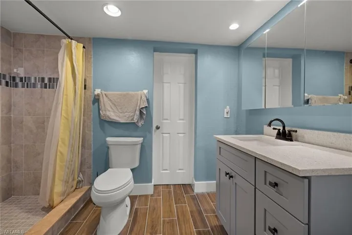 Bathroom with vanity, toilet, and walk in shower