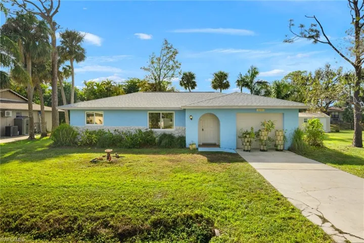 Single story home with cooling unit, a front lawn, and a garage
