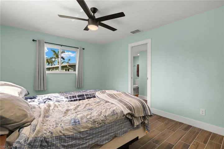 Bedroom featuring ceiling fan and ensuite bath