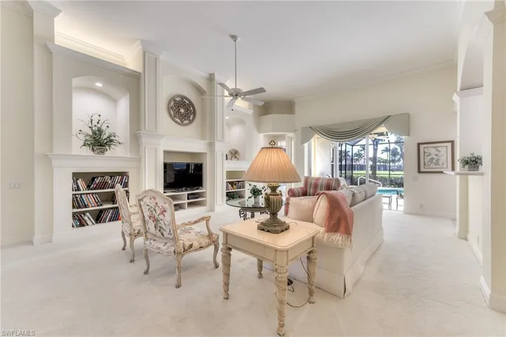 Living room with ceiling fan, crown molding, and light carpet