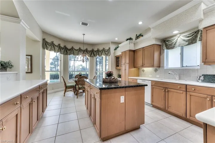 Kitchen with dishwasher, light tile floors, tasteful backsplash, and a kitchen island